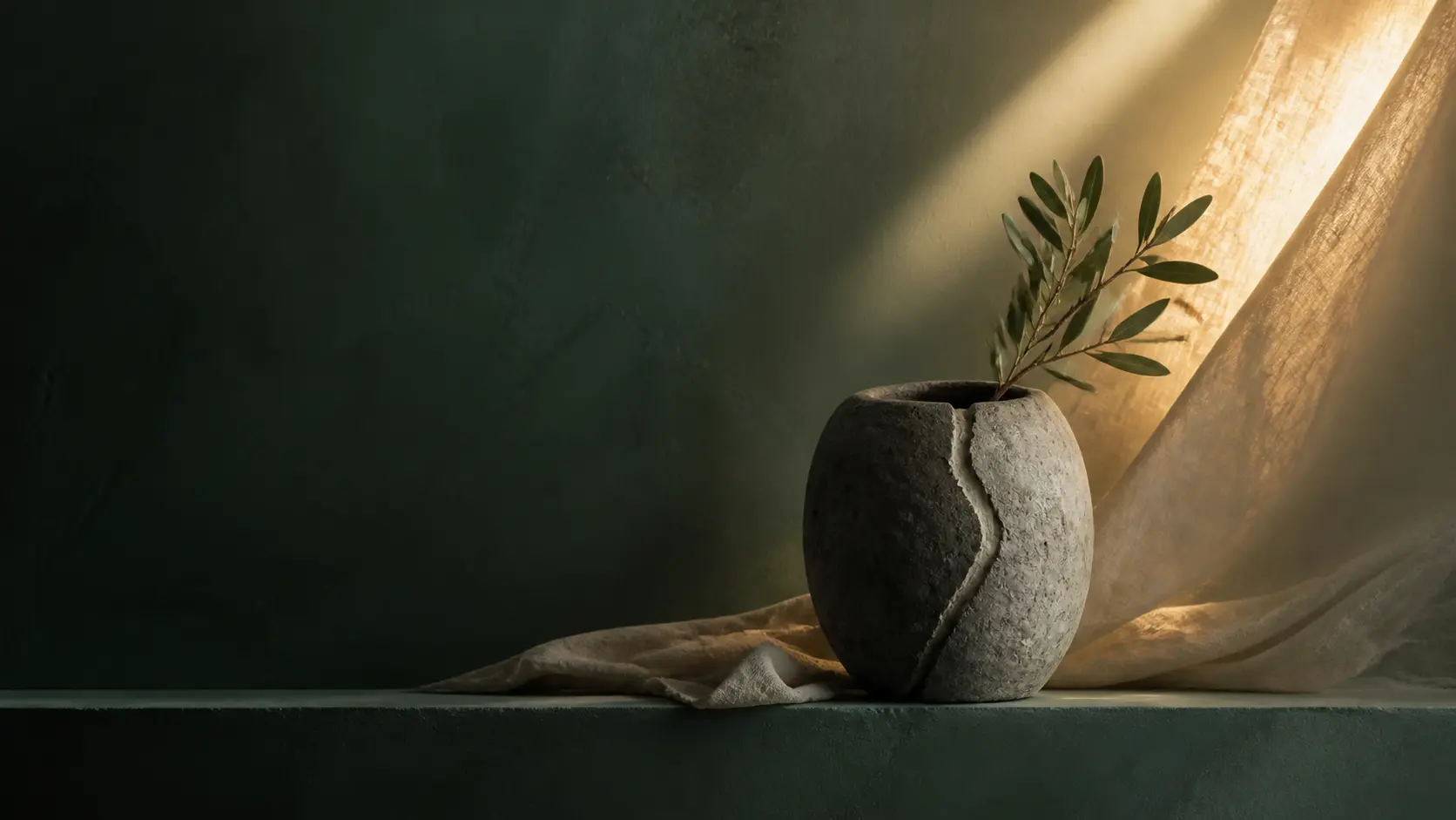 A repaired stone vessel holding an olive branch in a warm shaft of light